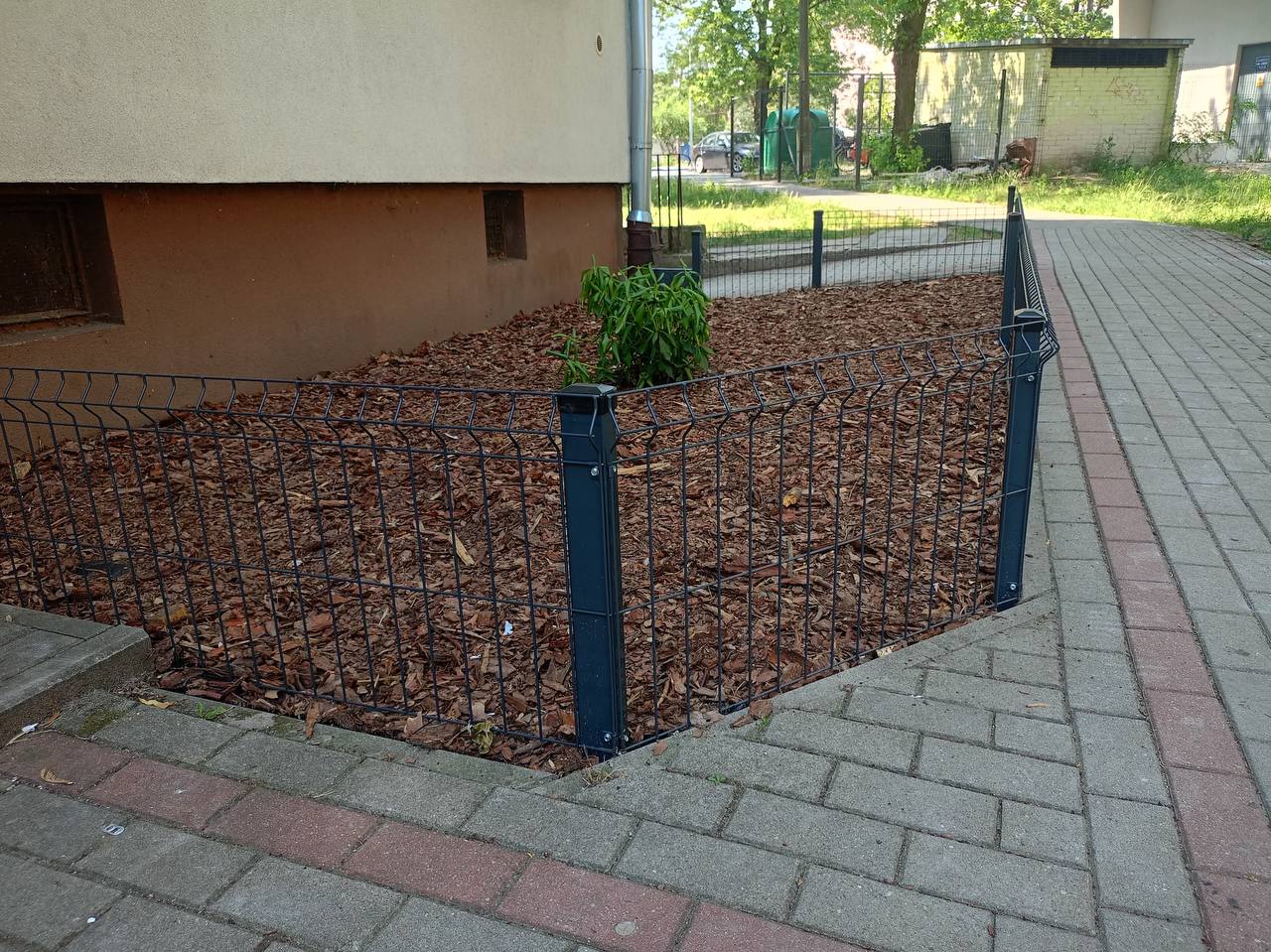 Detal montażu ogrodzenia panelowego 3D — narożnik przy klatce